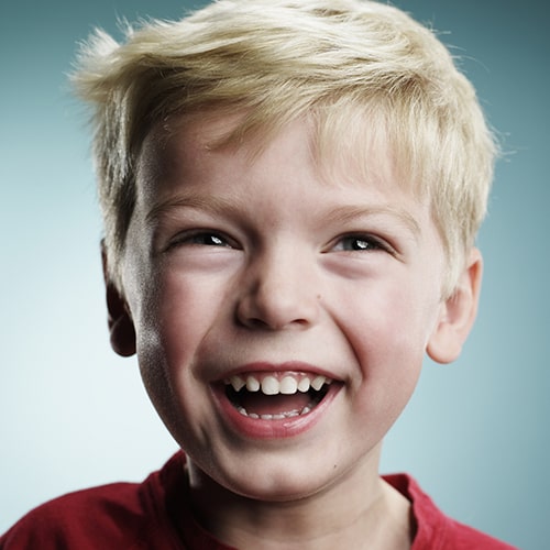 A boy smiling after his pulpotomy treatment