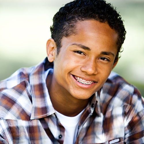 A young man with braces smiling