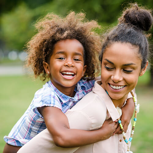 A mother in the park with her daughter smiling