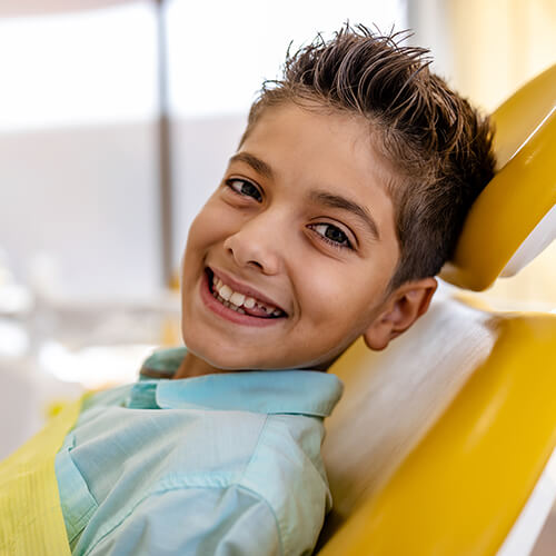 A boy sitting in the dentist's chair while waiting for his dental checkup